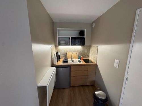 une petite cuisine avec un évier et un comptoir dans l'établissement La Casa - Appartement neuf proche Deauville, à Villers-sur-Mer