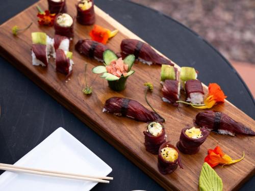 un plato de madera con algo de comida en una mesa en Wolwedans Desert lodge, en NamibRand