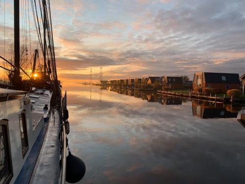 a boat is docked in the water at sunset at Recreatiepark Tusken de Marren in Akkrum