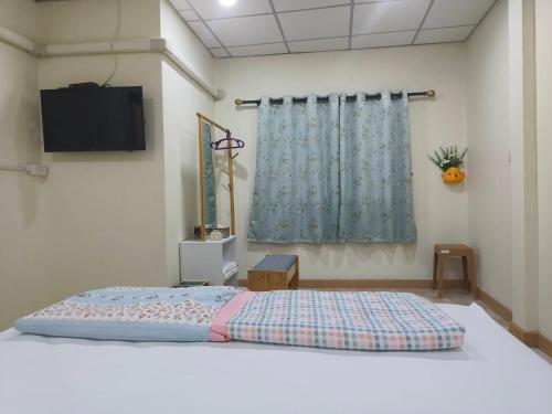 Sathani Hat YaiにあるAP Houseの壁にテレビが付いたベッドのある寝室