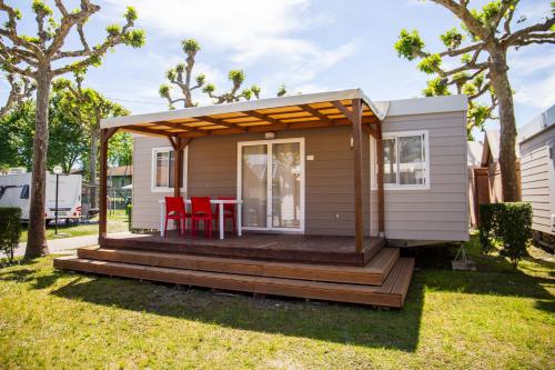 a tiny house with a deck in a yard at Camping Rose in Dormelletto
