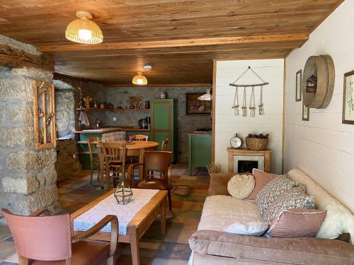 un salon avec un canapé et une table dans l'établissement La Borie Maisonnette de Charme en Pierres 80m2, à Chenereilles