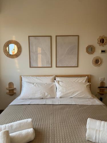 a bedroom with a bed with two pictures on the wall at Fly & chill in Ciampino