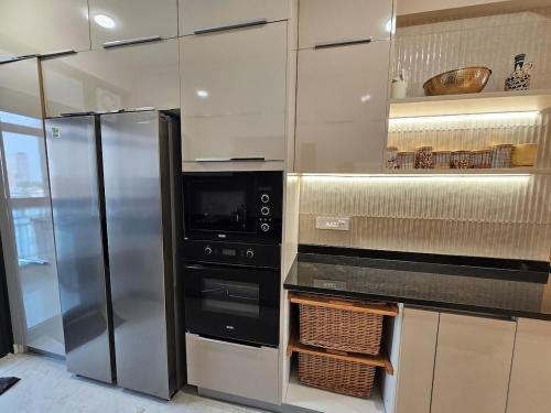 a kitchen with a refrigerator and a microwave at Luxury 4BHK in Greater Noida - 5 Min to India Expo in Greater Noida