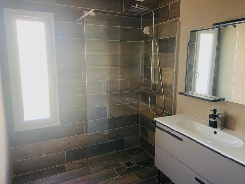 une salle de bain avec un lavabo et une douche dans l'établissement Maison méditerranéenne, à Cournonterral