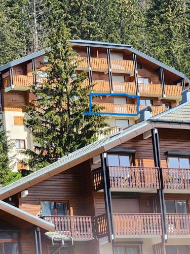 a large apartment building with a tree on the balcony at 2-bed appt 20 mins from Morzine Portes du Soleil French Alps in La Baume