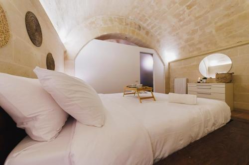 a bedroom with a white bed and a table at Dimora Castelvecchio-Sassi Di Matera in Matera