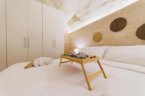 a bedroom with a bed with a table on it at Dimora Castelvecchio-Sassi Di Matera in Matera