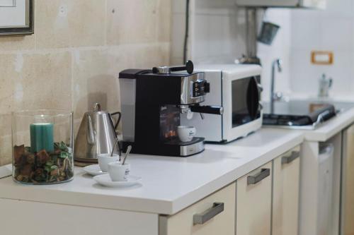 a kitchen counter with a coffee maker and a microwave at Dimora Castelvecchio-Sassi Di Matera in Matera