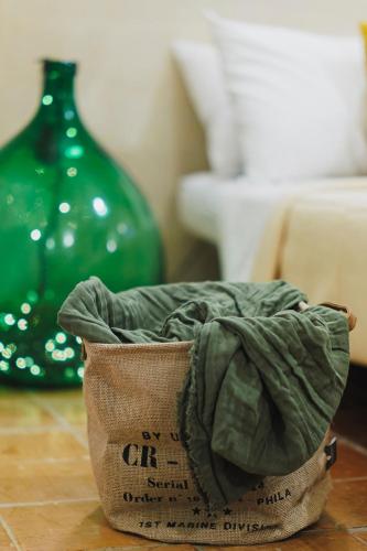 a bag of clothes sitting on the floor with a green vase at Dimora Castelvecchio-Sassi Di Matera in Matera