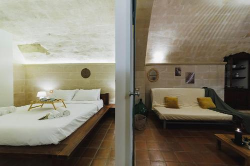 a bedroom with two beds and a table in a room at Dimora Castelvecchio-Sassi Di Matera in Matera