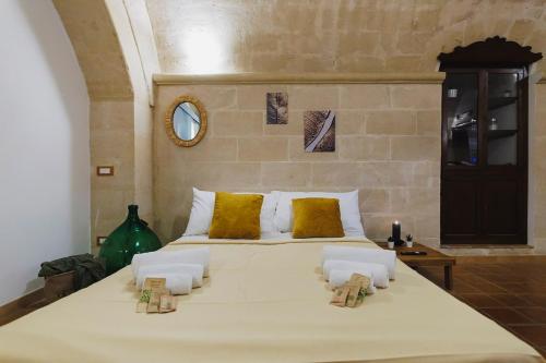 a bedroom with a large white bed with yellow pillows at Dimora Castelvecchio-Sassi Di Matera in Matera