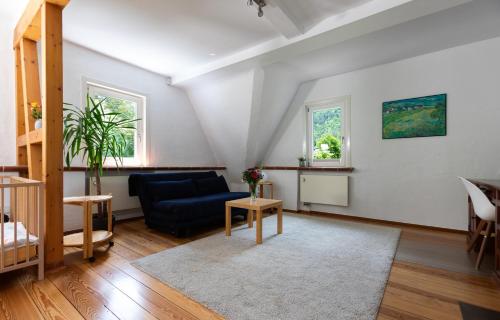 a living room with a blue couch and a table at Villa Sophie in Bad Herrenalb