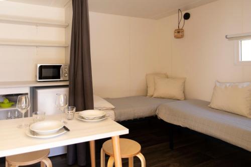 a small room with two beds and a table at Camping Rose in Dormelletto
