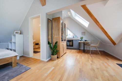 an attic room with a bed and a dining room at Kleiner Glücksort in Gillenfeld