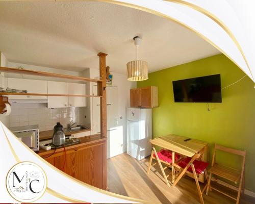 Il comprend une cuisine avec une petite table et des murs verts. dans l'établissement Studio on slopes, sled sleigh 5 peoples Ours 1, à Allos