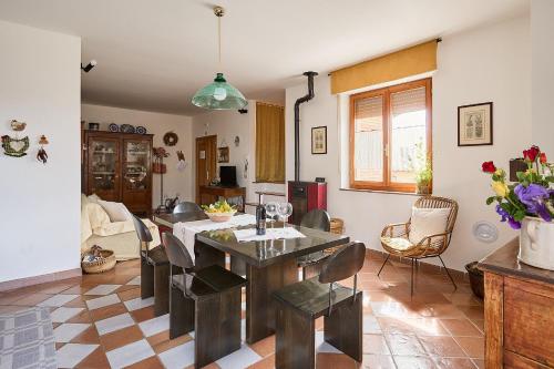 a kitchen and living room with a table and chairs at Villa PoliFlora in Monticchiello
