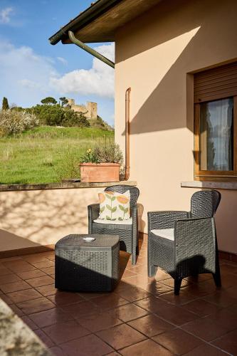 a patio with chairs and a table and a window at Villa PoliFlora in Monticchiello