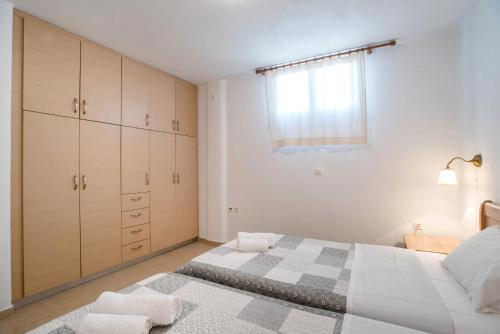 a bedroom with a large bed and a window at Blue Xenia Villas Paros in Chrissi Akti