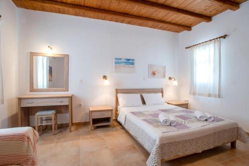 a bedroom with a bed and a table and a mirror at Blue Xenia Villas Paros in Chrissi Akti