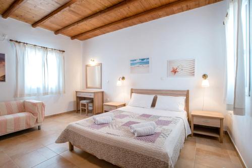 a bedroom with a large bed and a couch at Blue Xenia Villas Paros in Chrissi Akti