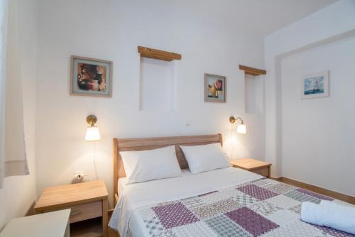 a bedroom with a bed with a quilt on it at Blue Xenia Villas Paros in Chrissi Akti