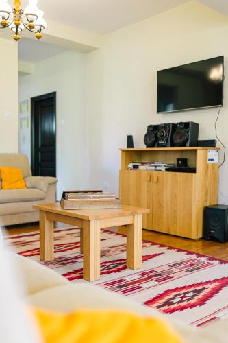 a living room with a coffee table and a flat screen tv at Pensiunea Tania-Nora in Alexandru cel Bun 