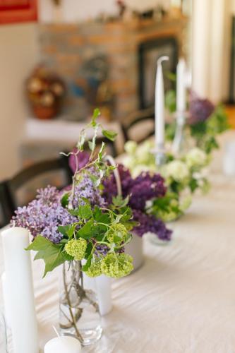 a table with purple and green flowers in a vase at Pensiunea Tania-Nora in Alexandru cel Bun 