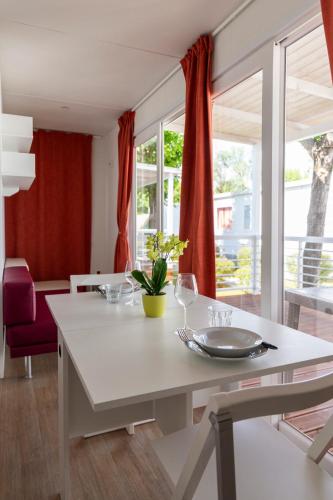 a dining room with a white table with wine glasses at Camping Rose in Dormelletto