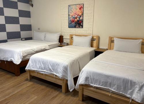 a room with two beds and a painting on the wall at 水源棧 in Fengyuan