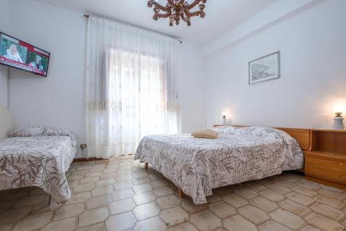 a bedroom with two beds and a chandelier at Casa Nonna Angela- Relax & Parcheggio Gratuito in Minori