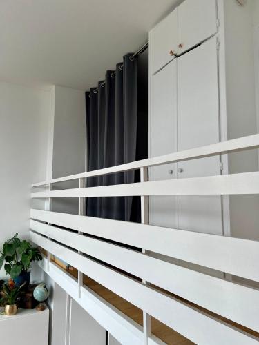 un escalier dans une pièce avec des armoires blanches dans l'établissement Un duplex de charme à Paris, à Paris