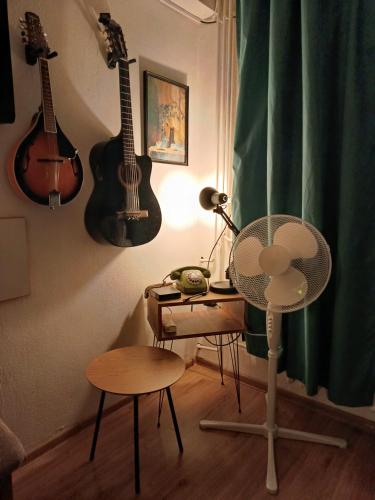 Habitación con 2 guitarras en la pared y escritorio. en Guns N' Roses, en Borča