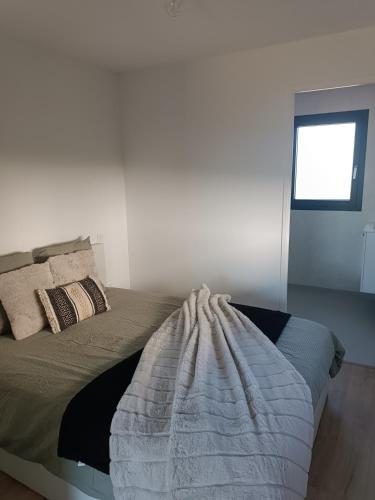 une chambre avec un lit avec une couverture dessus dans l'établissement Maison studio de jardin, à Naucelles
