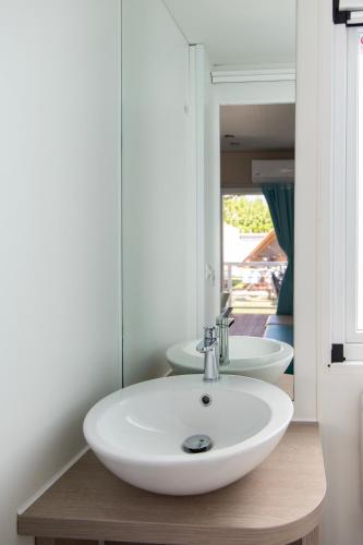 a bathroom with a white sink and a mirror at Camping Rose in Dormelletto