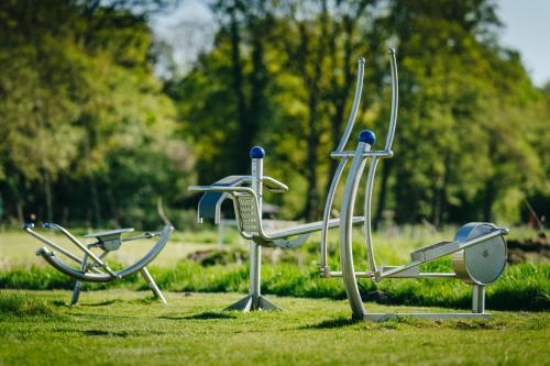 a group of chairs sitting on the grass in a park at Romantik Hotel Jagdhaus Eiden am See in Bad Zwischenahn