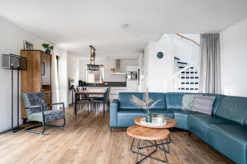 a living room with a blue couch and a table at Recreatiepark Tusken de Marren in Akkrum