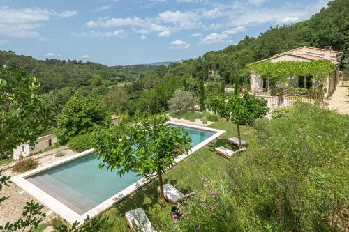 une image d'une piscine dans un jardin arboré dans l'établissement La Belle échappée holiday rental with pool in Menerbes, à Ménerbes