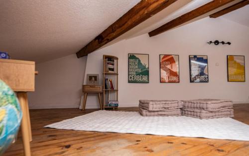 - un salon avec un canapé et des affiches murales dans l'établissement Refuge sous les toits, à Perpignan