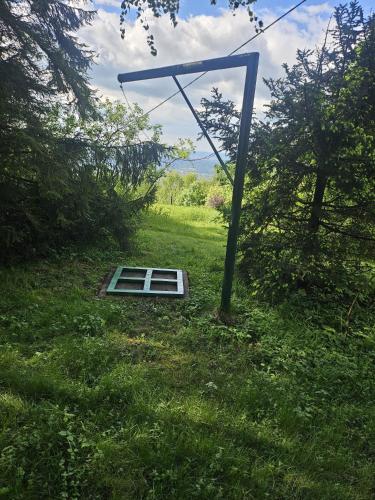 a window in a field with a pole in the grass at chata Oáza klidu v Beskydech in Hrádek