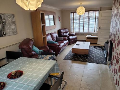 a living room with a couch and a table at The Holbein Three bedroom home near tilgate park private parking and garden in Crawley