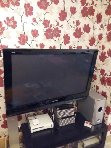 a flat screen tv sitting on top of a table at The Holbein Three bedroom home near tilgate park private parking and garden in Crawley