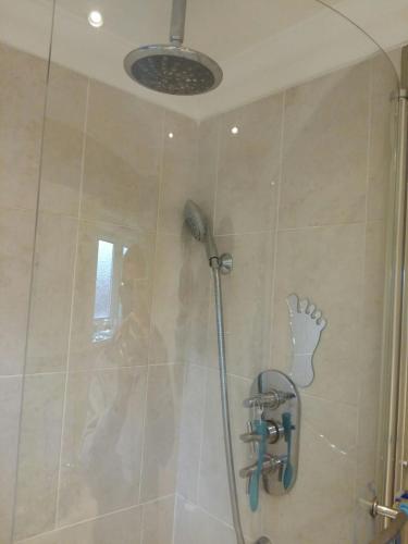 a shower with a shower head in a bathroom at The Holbein Three bedroom home near tilgate park private parking and garden in Crawley