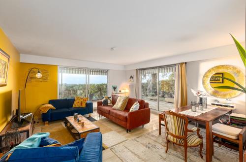 a living room with blue couches and a table at NICE luxury residence, Garden level with sea view and swimming pool, 2bedroom apartment of approximately 85 square meter and private garden in Nice