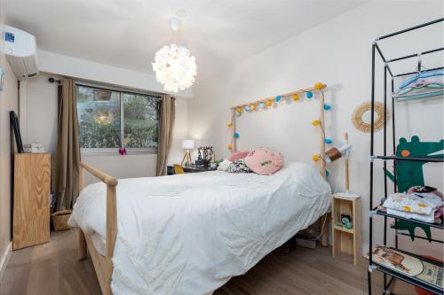 a bedroom with a bed and a chandelier at NICE luxury residence, Garden level with sea view and swimming pool, 2bedroom apartment of approximately 85 square meter and private garden in Nice