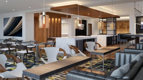 a restaurant with tables and chairs and a bar at Marriott Owings Mills Metro Centre in Owings Mills