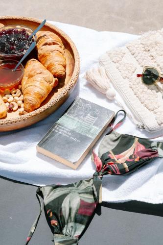 a table with a basket of pastries and a book at Mandilada Village in Samos in Marathokampos