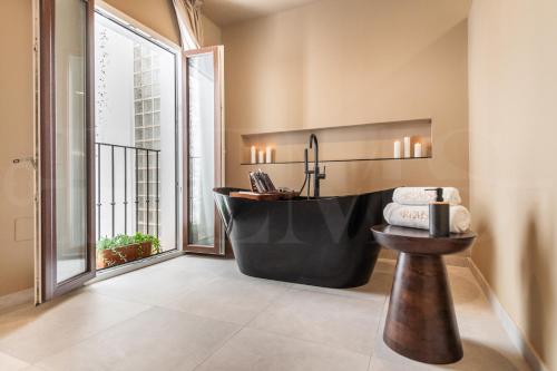 łazienka z czarną wanną i dużym oknem w obiekcie Penthouse & private rooftop in the heart of Malaga by REMS w Maladze