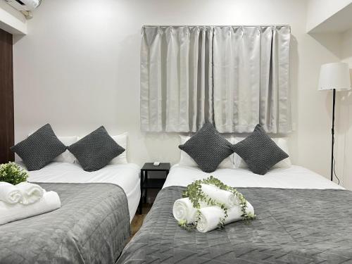 two beds sitting next to each other in a room at Ikebukuro Area 1F03 NishiikeApartment in Tokyo
