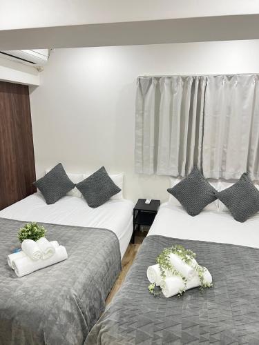 a hotel room with two beds with plants on them at Ikebukuro Area 1F03 NishiikeApartment in Tokyo